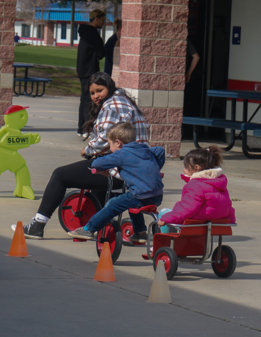 Little Apaches Colton Little and Anna Chong riding bikes beside junior Yvette Garcia on Feb. 16 in front of the 700 wing where Dixon’s class located on campus.
