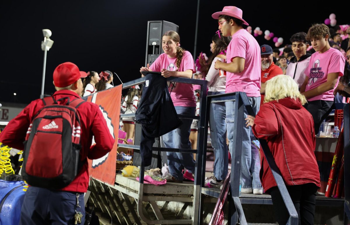 ASB Students Mackenzie Scott and Luke Pena talking to Athletic Director Brian Penner at varsity football game.